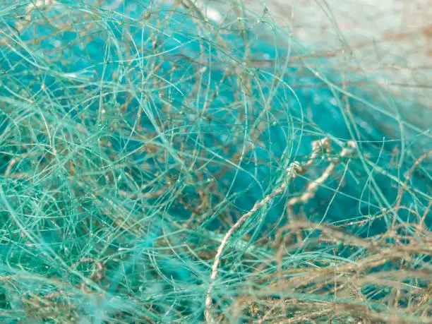 Mess of fishing nets and lines piled up in a fishing port