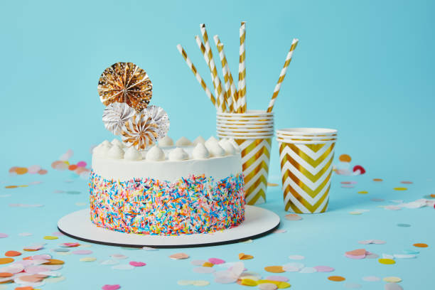 istock Delicious cake, plactic cups and drinking straws on blue background with confetti 1070239140
