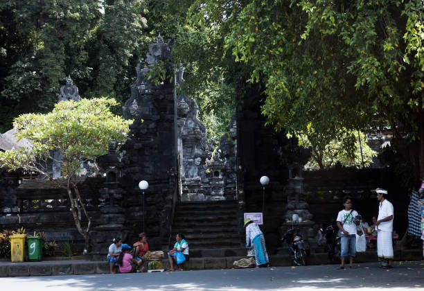 entrada al templo de pura goa lawah y población local - pura goa lawah fotografías e imágenes de stock