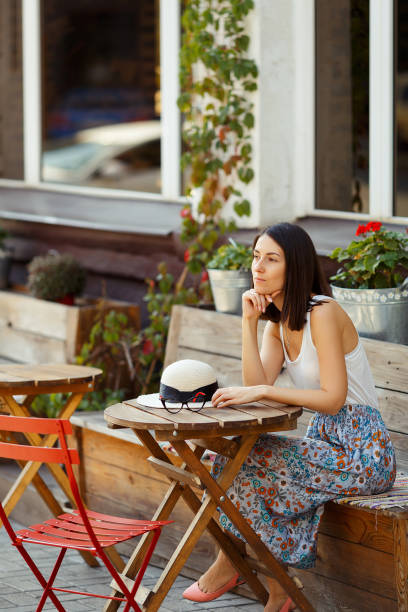 istock Beautiful Lady With A Hat Sitting On A Summer Terrace 1070241330