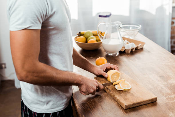 istock mid section of young man cutting lemon on chopping board 1070242864