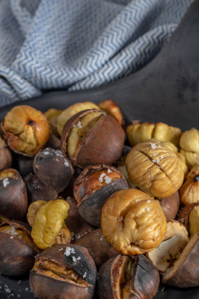 istock Roasted chestnuts in cast iron grilling pan over rustic wooden board. 1070245274