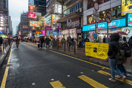 Busy street in Mong Kok area with neon-lighted sign boards. Hong Kong, Kowloon, January 2018