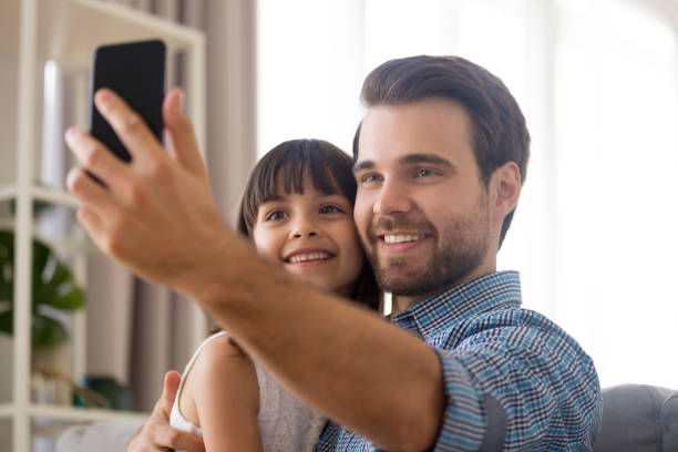 istock Father and daughter using smartphone take selfie photography 1070261796