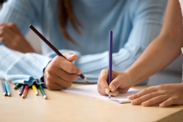 istock Close up hands mother and daughter drawing with colored pencils 1070261914