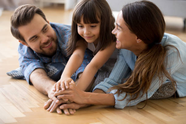 istock Diverse family lying on warm floor holding hands 1070262018