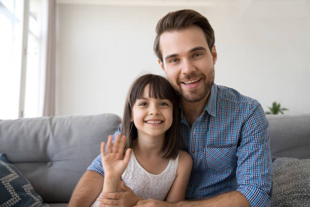 istock Father and daughter have video call sitting on couch 1070262096