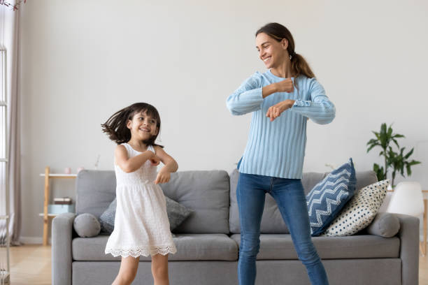 母と娘のリビング ルームで一緒に踊り - family indoors happiness laughing ストックフォトと画像