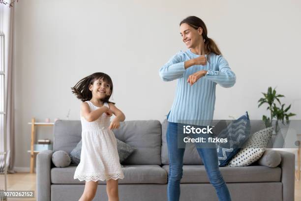 Mother And Daughter Dancing Together In Living Room Stock Photo - Download Image Now