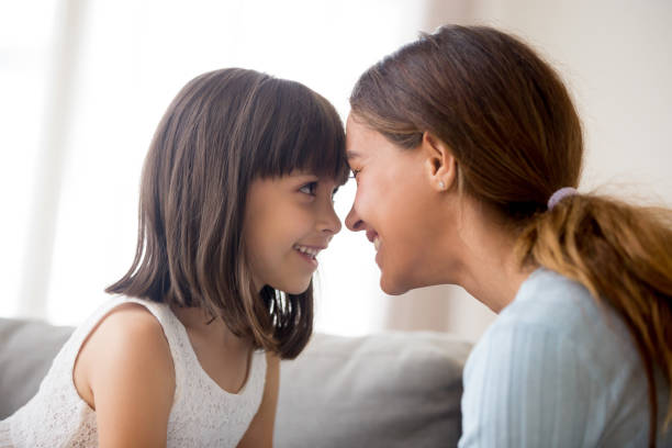 istock Mother and daughter touching with foreheads looking at each other 1070267314