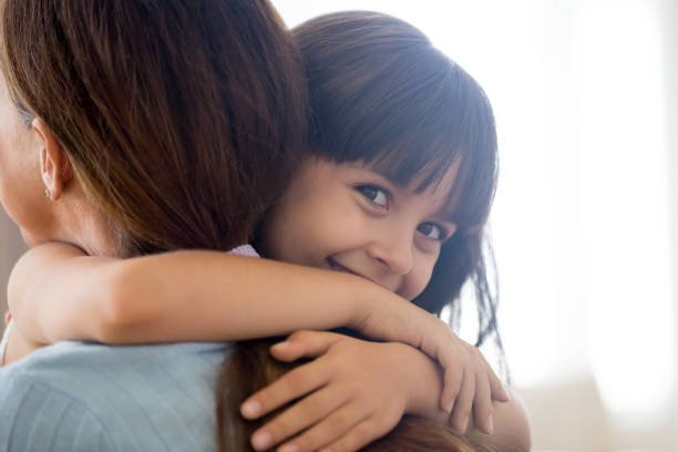 istock Happy daughter looking at camera embracing mother 1070267332