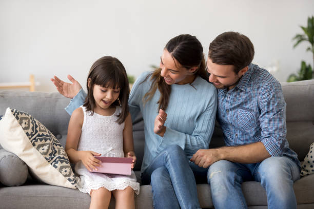 istock Parents congratulate loving daughter sitting together on couch 1070267424