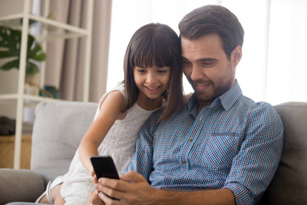 istock Father and little daughter spend free time using smartphone 1070267504