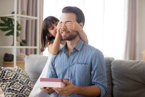 istock Daughter make gift for daddy cover him eyes with hands 1070267536