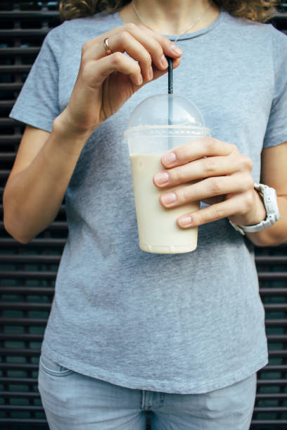 istock Young woman holding coffee latte in plastic transparent cup 1070267956