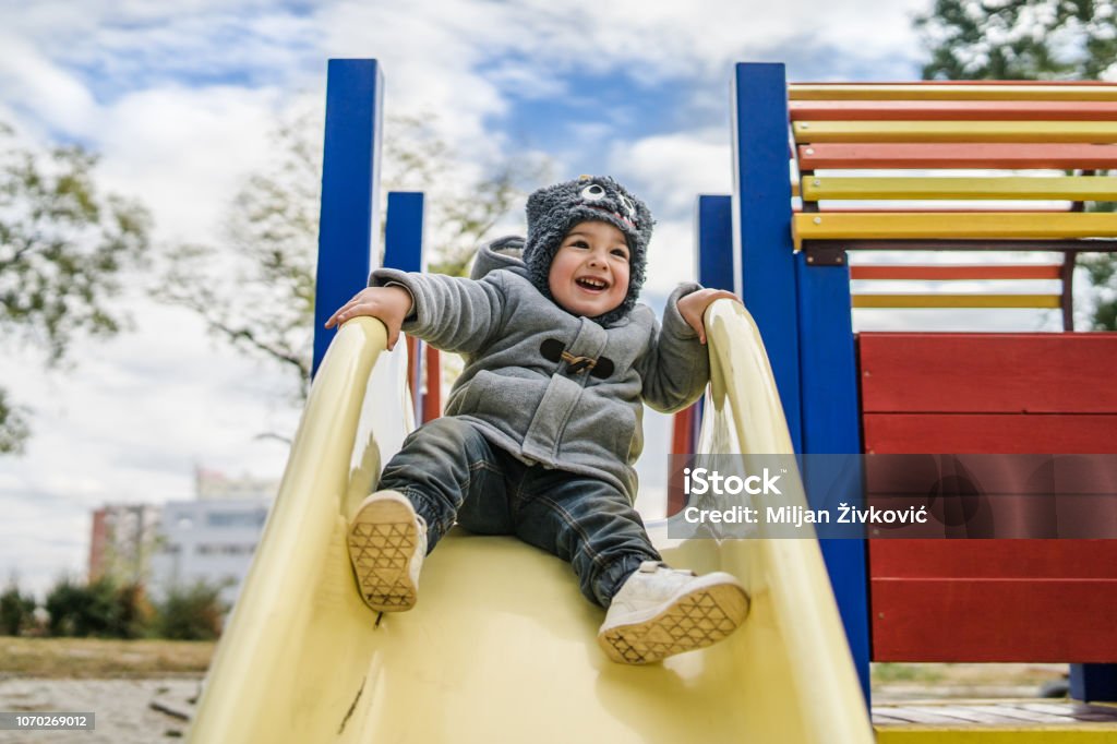 Bambino in scivolo nel parco - Foto stock royalty-free di Bambino