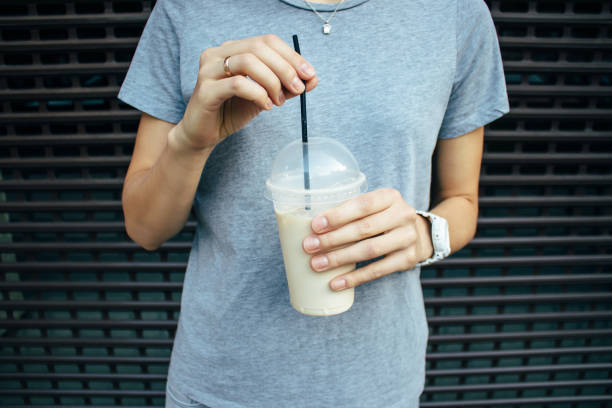 istock Young woman holding coffee latte in plastic transparent cup 1070269034