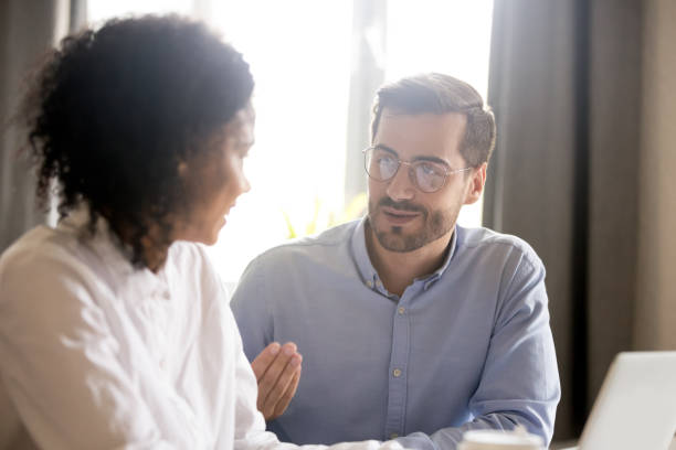 istock Friendly male mentor explaining african american female intern new project 1070271490