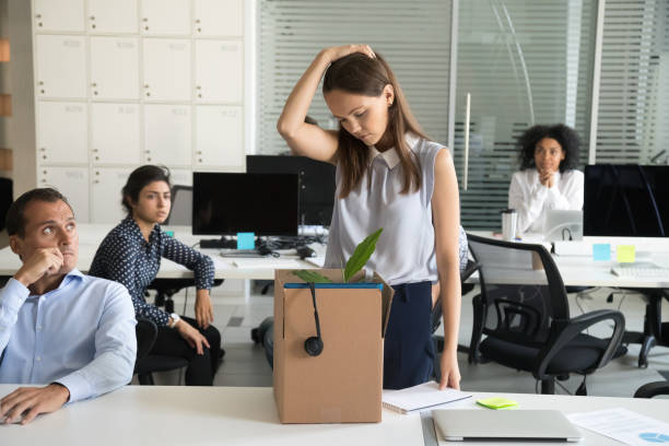Upset female employee packing box getting fired from job Upset female employee packing belongings in box, frustrated stressed girl getting fired from job ready to leave on last day at work, sad office worker desperate about unfair dismissal losing job evil corporation stock pictures, royalty-free photos & images