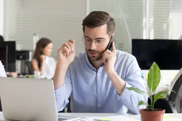 Photo of Sales manager consulting client talking on phone in office