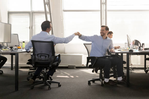 istock Friendly male buddies fist bumping at work celebrate good teamwork 1070271774