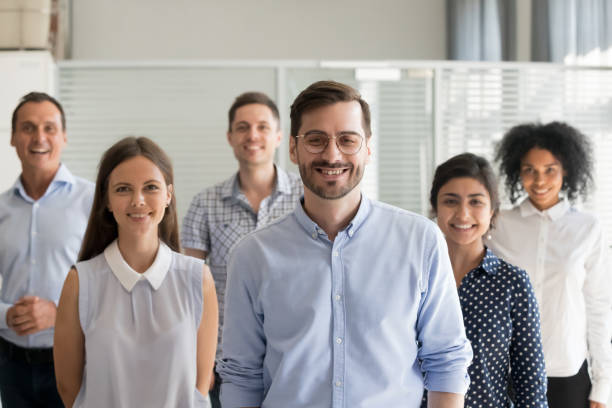 istock Smiling ceo looking at camera in office with diverse team 1070271836