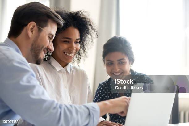 Diverse Happy Interns Listening To Mentor Explaining Online Project Stock Photo - Download Image Now