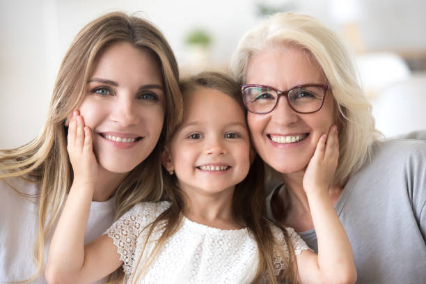 Portrait of girl hugging mom and grandmother making family picture Portrait of three generations of women look at camera posing for family picture, cute little girl hug mom and granny enjoy time at home, smiling mother, daughter and grandmother spend weekend together multi generation family photos stock pictures, royalty-free photos & images