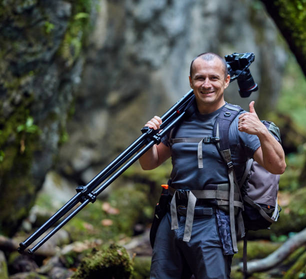 istock Professional nature photographer with camera on tripod 1070273710