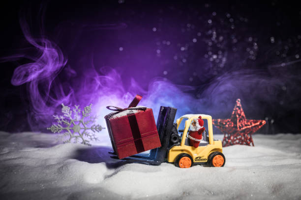 istock Miniature Gift Box by Forklift Machine on snow ,Determined Image for Christmas Holiday and Happy New Year Gift Celebration concept. 1070274162