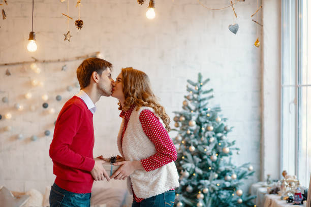 istock Young couple give Christmas presents to each other 1070276178