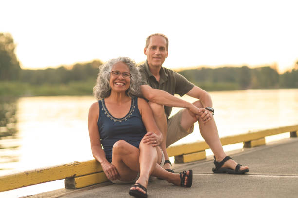 istock Interracial senior couple sit on the dock on a summer evening 1070321580