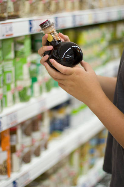 istock Female hand choosing balsamic vinegar in supermarket 1070322006