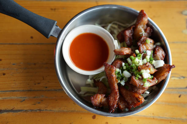 Deep fried pork serving with chili sauce in the small cooking pan