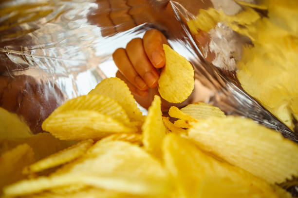 istock Hand hold potato chips inside snack foil bag 1070323786