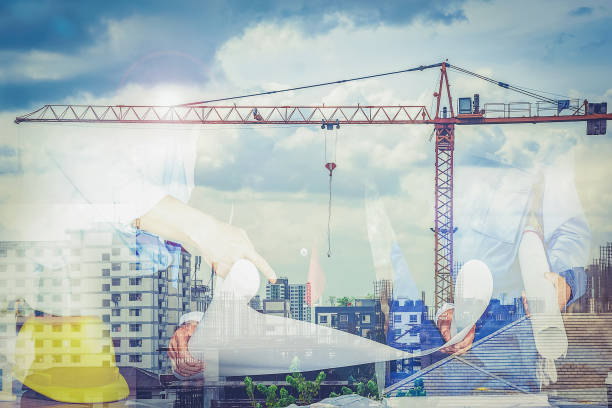 istock Engineering team with architects and crane lifts into the background. This is a double exposure image. 1070324418