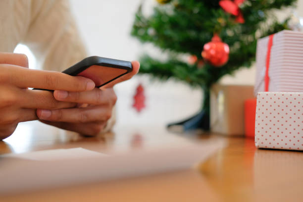 istock man using mobile smart phone with christmas decoration. xmas new year holiday celebration. 1070324644