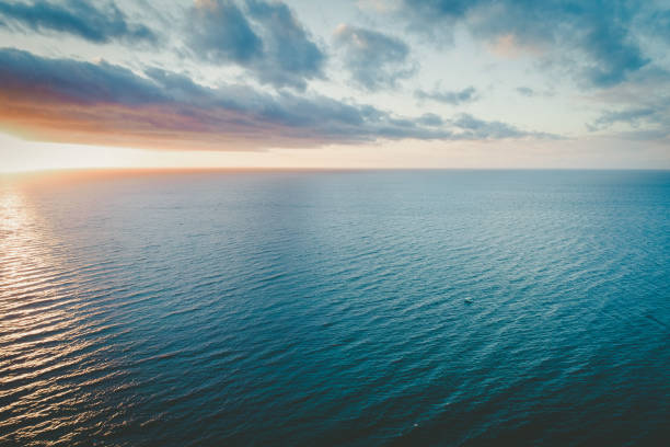 istock Lonely boat sailing calm ocean waters at sunset - aerial view 1070326518