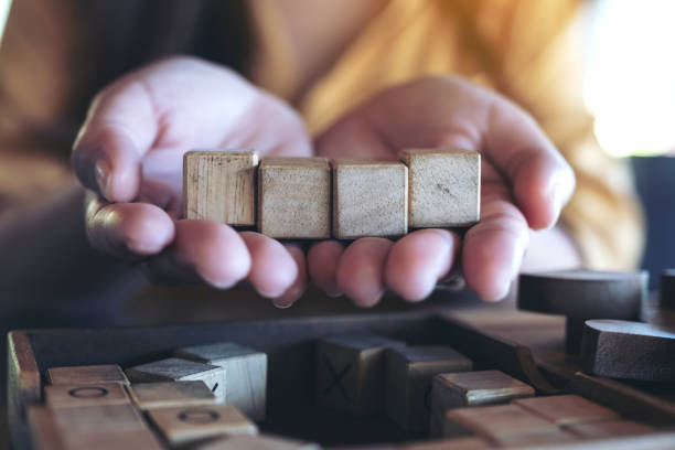 istock Woman's hands holding and showing four square wooden blocks 1070331148