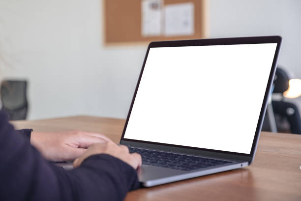 istock Mockup image of hands using and typing on laptop with blank white desktop screen while sitting in office 1070332966