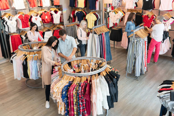 istock Multi ethnico group of people looking at clothes on racks at a store smiling 1070337656
