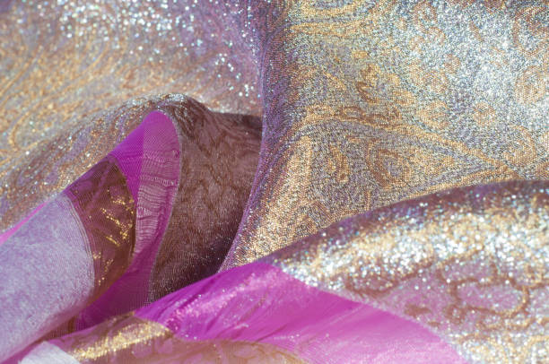 istock Texture, background, pattern. Combined silk white fabric and gold and silver damask fabric, pink ribbons 1070339678