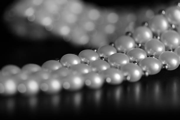 collier de perles blanche sur un fond sombre se bouchent. noir et blanc - black pearl pearl horizontal necklace photos et images de collection