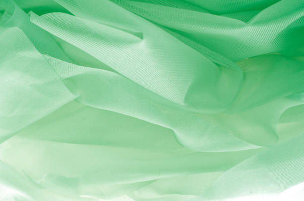 istock Texture, background, pattern. The texture of the silk fabric is green. Silk fabric is transparent. Fabric or liquid wave illustration of wavy creases of silk satin texture or velvet material 1070354894