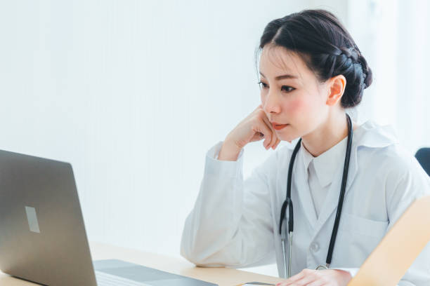 Portrait doctor women sitting working on note clipboard in medical office stock photo