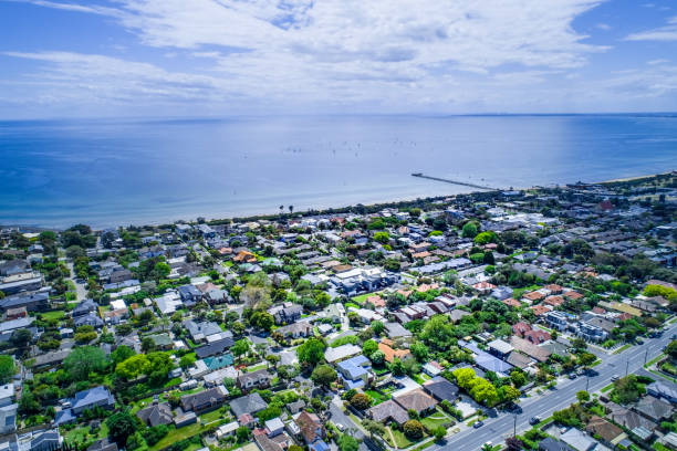 vista aérea da zona residencial perto do litoral do oceano e cais longo de madeira com veleiros. - costa victoria - fotografias e filmes do acervo