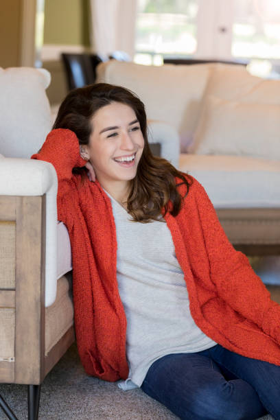 istock Young woman smiles while relaxing at home 1070362094