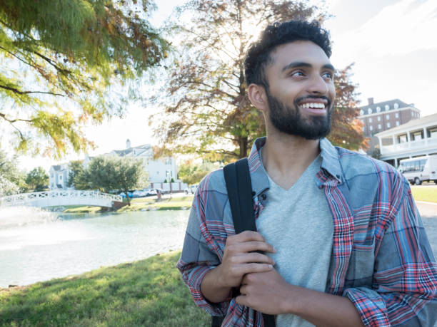 istock A young, male student smiles as he holds his backpack 1070362348