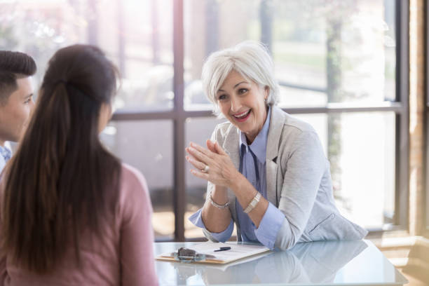 istock A young couple sit at a table and face a smiling, senior counselor 1070362416