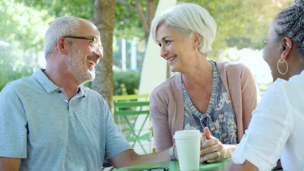 istock An older couple sit at a table with their daughter in a park 1070362460